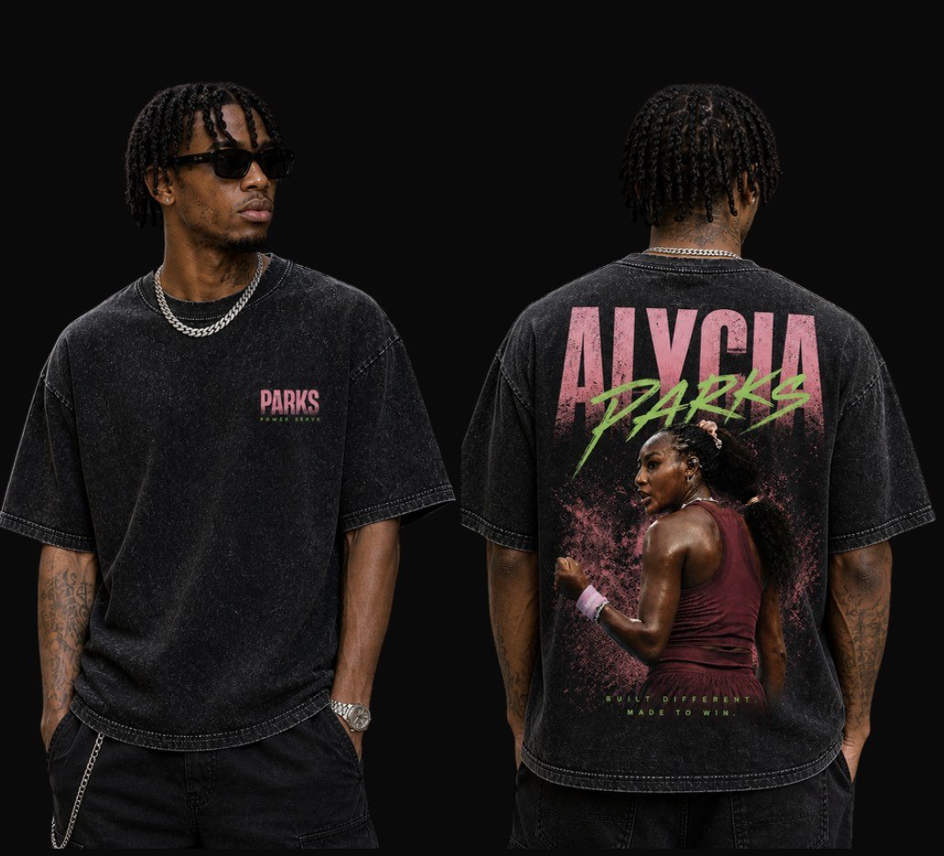 Statement Tee: washed black oversized tee with a small PARKS Power Serve chest print on the front and a large pink and green Alycia Parks graphic with her photo on the back